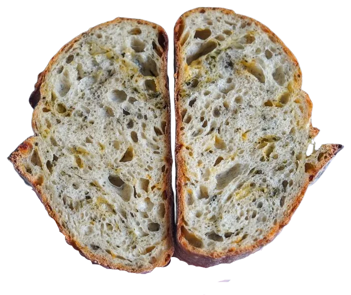 An inclusion sourdough loaf cut in half showing pesto and cheese folded through the crumb